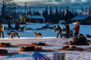 Volunteer checkers help park Tom Jamgochian's team in the morning at the Nikolai checkpoint during Iditarod 2016.  Alaska.  March 09, 2016.  Photo by Jeff Schultz (C) 2016 ALL RIGHTS RESERVED