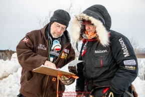 Volunteer checker Mark Greene checks in Allen Moore as he arrives at the Ruby checkpoint during the 2017 Iditarod on Thursday morning March 9, 2017.Photo by Jeff Schultz/SchultzPhoto.com  (C) 2017  ALL RIGHTS RESERVED