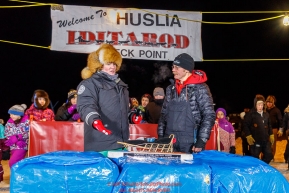 Mitch Seavey accepts the GCI Dorothy G. Page Halfway award from GCI rep Tara Wheatland at the Huslia checkpoint during the 2017 Iditarod on Thursday night  March 9, 2017.Photo by Jeff Schultz/SchultzPhoto.com  (C) 2017  ALL RIGHTS RESERVED