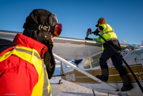 Volunteer Dave Robey helping to refueli an Iditarod Airforce plane for another quick turn to the Cripple checkpoint from McGrath.  Expecting overnight temperatures below -40F, Cripple was in need of a resupply of heating oil.