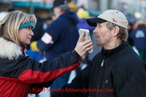 Radio reporter, Cheryl Mativa, interviews Paul Gebhardt along Fourth Avenue prior to the Iditarod 2014 Ceremonial start in downtown Anchorage, Alaska.Iditarod Sled Dog Race 2014PHOTO (c) BY JEFF SCHULTZ/IditarodPhotos.com -- REPRODUCTION PROHIBITED WITHOUT PERMISSION