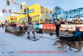 Rod Perry rides the gee pole as Dean Osmar drives the sled to reenact & demonstrate a Wells Fargo freight sled dur the Iditarod 2014 Ceremonial start in downtown Anchorage, Alaska.Iditarod Sled Dog Race 2014PHOTO (c) BY JEFF SCHULTZ/IditarodPhotos.com -- REPRODUCTION PROHIBITED WITHOUT PERMISSION