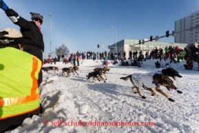 A longtime volunteer directs fans out of the way at the intersection of Fourth Avenue and Cordova Street during the ceremonial start to Iditarod 2014 in Anchorage, Alaska.Iditarod Sled Dog Race 2014PHOTO (c) BY JEFF SCHULTZ/IditarodPhotos.com -- REPRODUCTION PROHIBITED WITHOUT PERMISSION