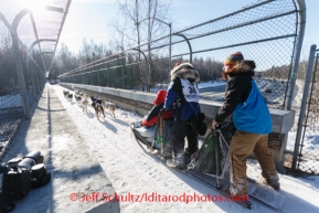 Veteran musher and multiple champion, Martin Buser, joined by his son, Rohn, drives his dog team along a bridge crossing Northern Lights Blvd. during the ceremonial start to Iditarod 2014 start in Anchorage, Alaska.Iditarod Sled Dog Race 2014PHOTO (c) BY JEFF SCHULTZ/IditarodPhotos.com -- REPRODUCTION PROHIBITED WITHOUT PERMISSION