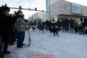 Martin Buser runs down 4th avenue past volunteers at a road crossing during the ceremonial start of the 2019 Iditarod in downtown Anchorage, Alaska on Saturday March 2.Photo by Jeff Schultz/  (C) 2019  ALL RIGHTS RESERVED