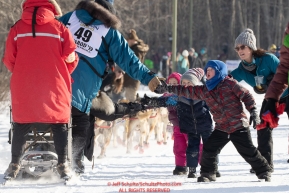 Youngster Kyde Friesen and family members give a high-five to musher Ryan Santiago during the ceremonial start of the 2019 Iditarod in midtown Anchorage, Alaska on Saturday March 2.Photo by Jeff Schultz/  (C) 2019  ALL RIGHTS RESERVED