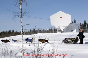 Saturday March 10, 2012  Anjanette Steer passes by a GCI communications dish as she leaves the Galena checkpoint. Iditarod 2012.