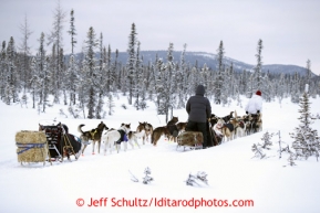 Michelle Phillips leads Josh Cadzow 's dogs past her team as he passes a few miles after leaving the Kaltag checkpoint on Sunday March 10, 2013.Iditarod Sled Dog Race 2013Photo by Jeff Schultz copyright 2013 DO NOT REPRODUCE WITHOUT PERMISSION