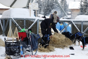 Matt Failor unpacks straw for his dogs to rest on at the Kaltag checkpoint on Sunday March 10, 2013.Iditarod Sled Dog Race 2013Photo by Jeff Schultz copyright 2013 DO NOT REPRODUCE WITHOUT PERMISSION