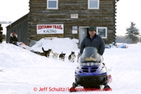 Volunteer Richard Burnham leads Kelley Griffin into the Kaltag checkpoint on Sunday March 10, 2013.Iditarod Sled Dog Race 2013Photo by Jeff Schultz copyright 2013 DO NOT REPRODUCE WITHOUT PERMISSION