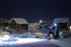 Musher Josh Cadzow watches his team eat during a light snowfall  in the early morning at the Kaltag checkpoint on Sunday March 10, 2013.Iditarod Sled Dog Race 2013Photo by Jeff Schultz copyright 2013 DO NOT REPRODUCE WITHOUT PERMISSION