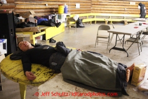 Musher Mike Williams Jr. sleeps on a table insie the community center at the Kaltag checkpoint on Sunday March 10, 2013.Iditarod Sled Dog Race 2013Photo by Jeff Schultz copyright 2013 DO NOT REPRODUCE WITHOUT PERMISSION