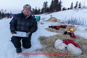 Volunteer night-time checker Margaret Douglas of Koyuk checks dogs at Koyuk on Monday March 10, during the Iditarod Sled Dog Race 2014.PHOTO (c) BY JEFF SCHULTZ/IditarodPhotos.com -- REPRODUCTION PROHIBITED WITHOUT PERMISSION