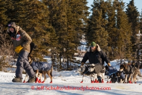 Robert Sorlie, and volunteer, Josh Capps, help Sorlie's dogs along glare ice in Koyuk on Monday, March 10, during the Iditarod Sled Dog Race 2014.PHOTO (c) BY JEFF SCHULTZ/IditarodPhotos.com -- REPRODUCTION PROHIBITED WITHOUT PERMISSION