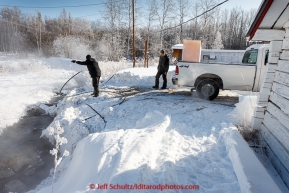 Volunteers get hot water for the dogs from the Hot Springs at the checkpoint of Manley Hot Springs on March 10, 2015.  Duirng the 2015 Iditarod.(C) Jeff Schultz/SchultzPhoto.com - ALL RIGHTS RESERVED DUPLICATION  PROHIBITED  WITHOUT  PERMISSION