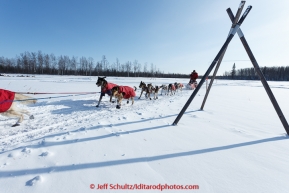 Ben Harper runs past a tripod as he leaves Manley Hot Springs in the afternoon on March 10, 2015.  2015 Iditarod.(C) Jeff Schultz/SchultzPhoto.com - ALL RIGHTS RESERVED DUPLICATION  PROHIBITED  WITHOUT  PERMISSION