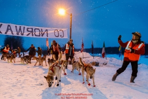 Volunteers lead Ed Stielstra dogs to the line at the Takotna checkpoint after his 24-hour layover in the early morning on Thursday March 10 during Iditarod 2016.  Alaska.    Photo by Jeff Schultz (C) 2016  ALL RIGHTS RESERVED