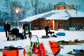 Volunteer veterinarians check over a team outside the community center as a near-full moon sets over the Huslia checkpoint during the 2017 Iditarod on Friday morning March 10, 2017.Photo by Jeff Schultz/SchultzPhoto.com  (C) 2017  ALL RIGHTS RESERVED