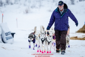 Volunteer Chris Kelley leads Rob Cook's team as he leaves at the ghost-town checkpoint of Iditarod on Saturday, March 10th during the 2018 Iditarod Sled Dog Race -- AlaskaPhoto by Jeff Schultz/SchultzPhoto.com  (C) 2018  ALL RIGHTS RESERVED