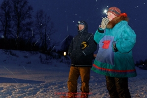 Volunteer checkers Brad VanMeter and Madeline Rubida call in out times to comms the early morning hours at the ghost-town checkpoint of Iditarod on Saturday, March 10th during the 2018 Iditarod Sled Dog Race -- AlaskaPhoto by Jeff Schultz/SchultzPhoto.com  (C) 2018  ALL RIGHTS RESERVED