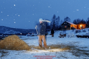 Longtime volunteer Brad VanMeter rakes straw in the early morning hours at the ghost-town checkpoint of Iditarod on Saturday, March 10th during the 2018 Iditarod Sled Dog Race -- AlaskaPhoto by Jeff Schultz/SchultzPhoto.com  (C) 2018  ALL RIGHTS RESERVED