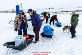 Volunteers unload supplies from Jerry Wortley's plane as dropped dogs are about to be loaded at the ghost-town checkpoint of Iditarod on Saturday, March 10th during the 2018 Iditarod Sled Dog Race -- AlaskaPhoto by Jeff Schultz/SchultzPhoto.com  (C) 2018  ALL RIGHTS RESERVED