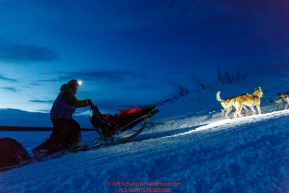 Linwood Fiedler and team run up the bank of the Yukon River and into the Kaltag checkpoint as dawn breaks on Sunday March 10th during the 2019 Iditarod Trail Sled Dog Race.Photo by Jeff Schultz/  (C) 2019  ALL RIGHTS RESERVED
