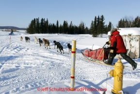 Sunday March 11, 2012  Braxton Peterson runs through the streets of Kaltag and past a fire hydrant on his way out of the checkpoint. Iditarod 2012.