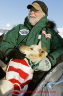 Sunday March 11, 2012   Volunteer vet Stan Diment holds a dropped dog from  Hugh Neff 's team in a sled headed to the airport at the Kaltag checkpoint. Iditarod 2012.