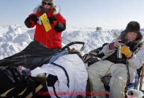 Sunday March 11, 2012 DeeDee Jonrowe rests on her sled in Unalakleet with a thermos in her hand.  Iditarod 2012.