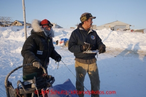 Les Ivanoff checks in Kelley Griffin in the morning at the Unalakleet checkpoint on Monday March 11, 2013.Iditarod Sled Dog Race 2013Photo by Jeff Schultz copyright 2013 DO NOT REPRODUCE WITHOUT PERMISSION