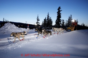 Mitch Seavey heads out of the Elim checkpoint with his headlamp on at dusk on Monday March 11, 2013.Iditarod Sled Dog Race 2013Photo by Jeff Schultz copyright 2013 DO NOT REPRODUCE WITHOUT PERMISSION