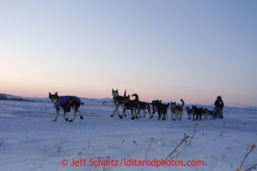 Bob Bundtzen runs on the trail out of the Unalakleet checkpoint as dawn breakks on Monday March 11, 2013.Iditarod Sled Dog Race 2013Photo by Jeff Schultz copyright 2013 DO NOT REPRODUCE WITHOUT PERMISSION