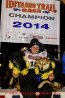 Dallas Seavey poses on the winner's stand with his lead dogs Beatle (L) and Reef after winning the 2014 Iditarod in record time of 8 days 13 hours 4 minutes and 19 seconds.   Tuesday, March 11, 2014.  Iditarod Sled Dog Race 2014.PHOTO (c) BY JEFF SCHULTZ/IditarodPhotos.com -- REPRODUCTION PROHIBITED WITHOUT PERMISSION