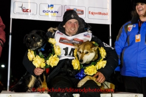 Dallas Seavey poses on the winner's stand with his lead dogs Beatle (L) and Reef after winning the 2014 Iditarod in record time of 8 days 13 hours 4 minutes and 19 seconds.   Tuesday, March 11, 2014.  Iditarod Sled Dog Race 2014.PHOTO (c) BY JEFF SCHULTZ/IditarodPhotos.com -- REPRODUCTION PROHIBITED WITHOUT PERMISSION