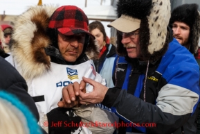 Martin Buser shows his broken fingers to Dr. Michael McNamara shortly after he crossed the finish line in 6th place at Nome on Tuesday March 11th during the 2014 Iditarod Sled Dog Race.PHOTO (c) BY JEFF SCHULTZ/IditarodPhotos.com -- REPRODUCTION PROHIBITED WITHOUT PERMISSION