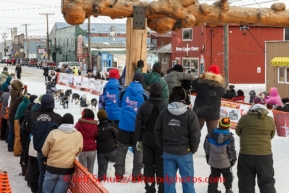 Jessie Royer runs down the finish chute to the burl arch for 7th place in Nome on Tuesday, March 11th during the 2014 Iditarod Sled Dog Race.PHOTO (c) BY JEFF SCHULTZ/IditarodPhotos.com -- REPRODUCTION PROHIBITED WITHOUT PERMISSION