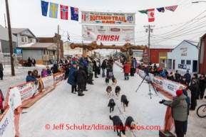 Jessie Royer's dog team is escorted out of the finishing chute on Front Street after arriving into Nome on Tuesday March 11th during the 2014 Iditarod Sled Dog Race.PHOTO (c) BY JEFF SCHULTZ/IditarodPhotos.com -- REPRODUCTION PROHIBITED WITHOUT PERMISSION
