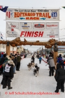 Ray Redington Jr. runs up the finish chute and under the burl arch finish line for 8th place in Nome on Tuesday March 11th during the 2014 Iditarod Sled Dog Race.PHOTO (c) BY JEFF SCHULTZ/IditarodPhotos.com -- REPRODUCTION PROHIBITED WITHOUT PERMISSION
