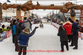 Hans Gatt runs into the finish chute and through the burl arch finish line in Nome to claim 9th place on Tuesday March 11th during the 2014 Iditarod Sled Dog Race.PHOTO (c) BY JEFF SCHULTZ/IditarodPhotos.com -- REPRODUCTION PROHIBITED WITHOUT PERMISSION