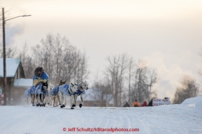 Seth Barnes runs down the road as he leaves the Tanana checkpoint on Wednesday morning  March 11th during the 2015 Iditarod.(C) Jeff Schultz/SchultzPhoto.com - ALL RIGHTS RESERVED DUPLICATION  PROHIBITED  WITHOUT  PERMISSION