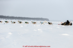 Jim Lanier sits on his sled as he runs down the Yukon river after leaving  the Tanana checkpoint on Wednesday morning  March 11th during the 2015 Iditarod.(C) Jeff Schultz/SchultzPhoto.com - ALL RIGHTS RESERVED DUPLICATION  PROHIBITED  WITHOUT  PERMISSION