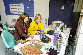 Volunteer Comms Carey Libershal and Martha Dobson log in/out times at the Tanana checkpoint on Wednesday morning  March 11th during the 2015 Iditarod.(C) Jeff Schultz/SchultzPhoto.com - ALL RIGHTS RESERVED DUPLICATION  PROHIBITED  WITHOUT  PERMISSION