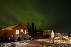 The cook shack and comms tent house volunteers as the Northern lights light up the sky at the Cripple checkpoint on Thursday March 10 during Iditarod 2016.  Alaska.    Photo by Jeff Schultz (C) 2016  ALL RIGHTS RESERVED