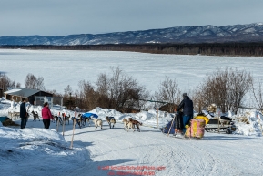 Wade Marrs runs down the road as he leave the Ruby checkpoint with the Yukon River in the background on Friday March 11 during Iditarod 2016.  Alaska.    Photo by Jeff Schultz (C) 2016  ALL RIGHTS RESERVED