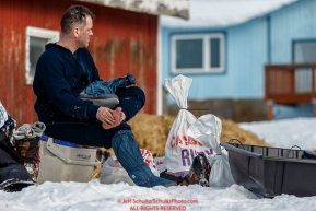 Jason Campeau dries his feet at the Ruby Checkpoint during the 2016 Iditarod.  March 11, 2016    Photo by Jeff Schultz (C) 2016  ALL RIGHTS RESERVED