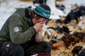 Norwegian musher Geir Idar Hjelvik eats a heated meal while resting at the Ruby Checkpoint during the 2016 Iditarod.  March 11, 2016    Photo by Jeff Schultz (C) 2016  ALL RIGHTS RESERVED