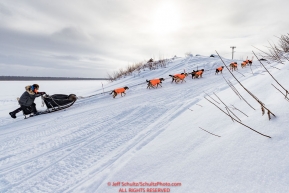 Martin Buser runs up the bank of the Yukon River and into the Kaltag village checkpoint on Sunday afternoon March 11th during the 2018 Iditarod Sled Dog Race -- AlaskaPhoto by Jeff Schultz/SchultzPhoto.com  (C) 2018  ALL RIGHTS RESERVED