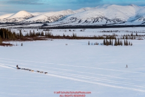 A team runs on the trail between Kaltag and Unalakleet with the Whaleback mountains in the background on Sunday evening March 11th during the 2018 Iditarod Sled Dog Race -- AlaskaPhoto by Jeff Schultz/SchultzPhoto.com  (C) 2018  ALL RIGHTS RESERVED