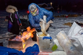 Jessie Royer prepares her dog's meal at the Kaltag village checkpoint on Sunday morning March 11th during the 2018 Iditarod Sled Dog Race -- AlaskaPhoto by Jeff Schultz/SchultzPhoto.com  (C) 2018  ALL RIGHTS RESERVED